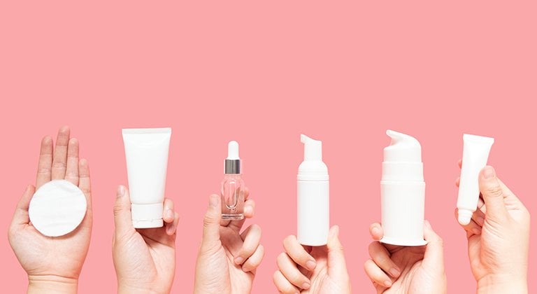 Mani che tengono prodotti per la skin-care
