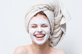 Ragazza con maschera all'argilla sul volto