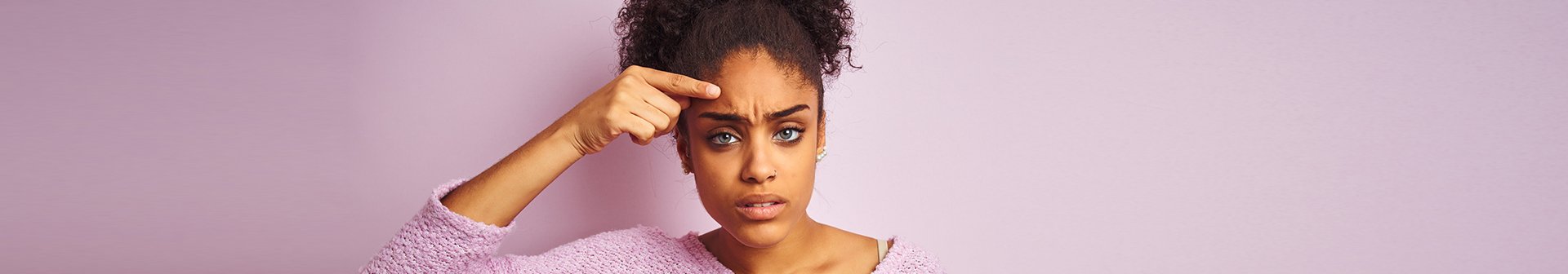 Ragazza si indica brufoli sulla fronte