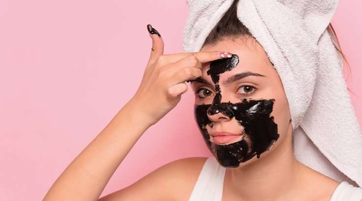 Ragazza che distende maschera nera sul viso