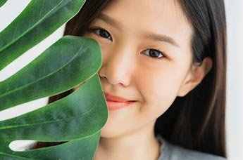 viso di ragazza e foglia verde