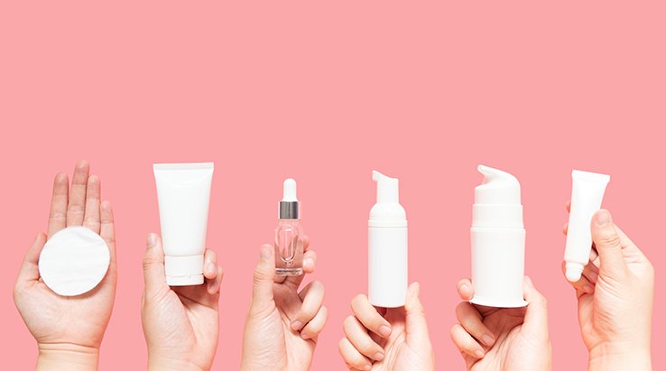 Mani che tengono prodotti per la skin-care